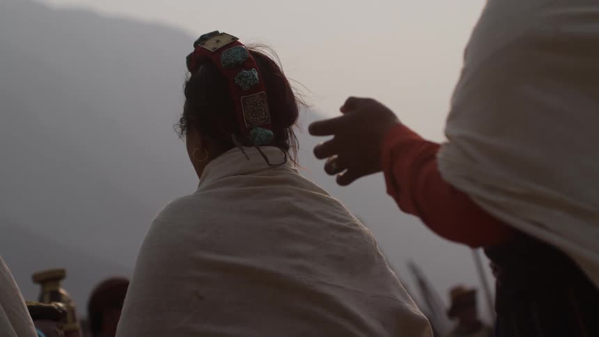 Back view of women with white cloth walking in an outdoor environment