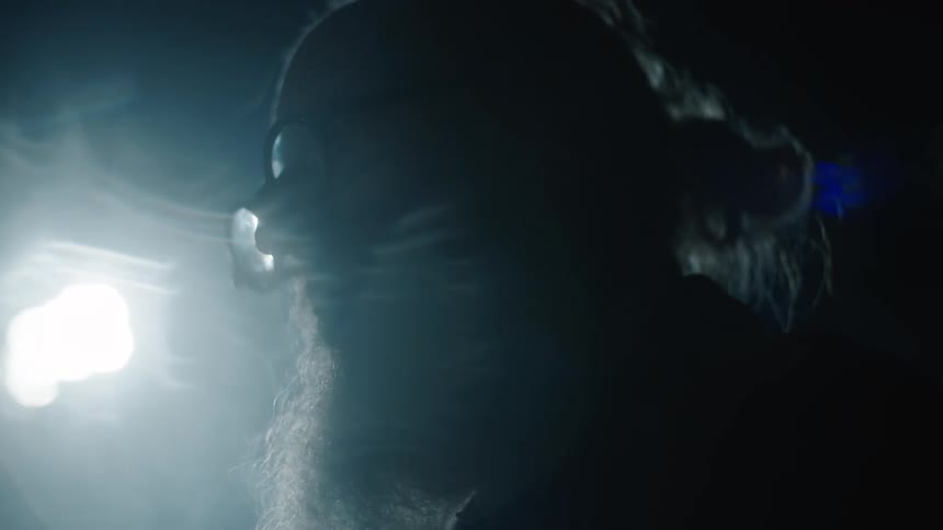 An old man stands under the lamp post at night