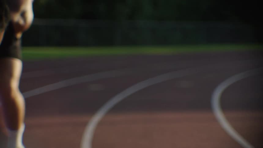 An athlete in a starting position on a track ready to sprint