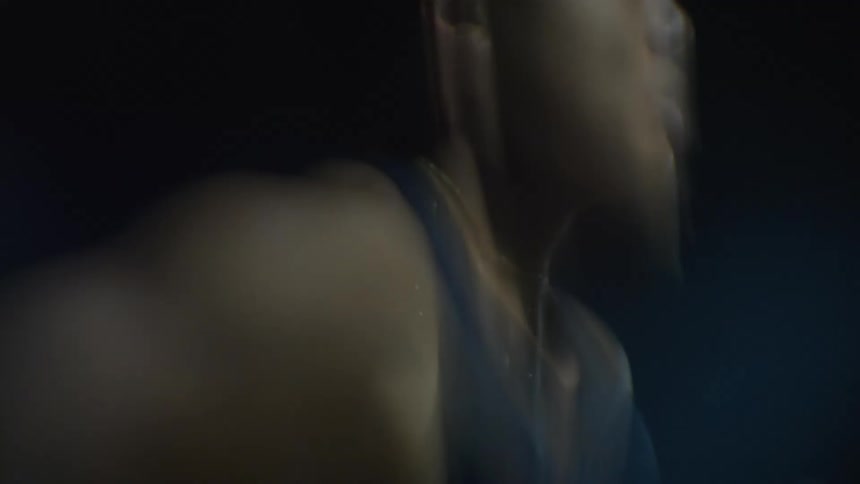 A timelapse of a man running quickly in an outdoor environment at night