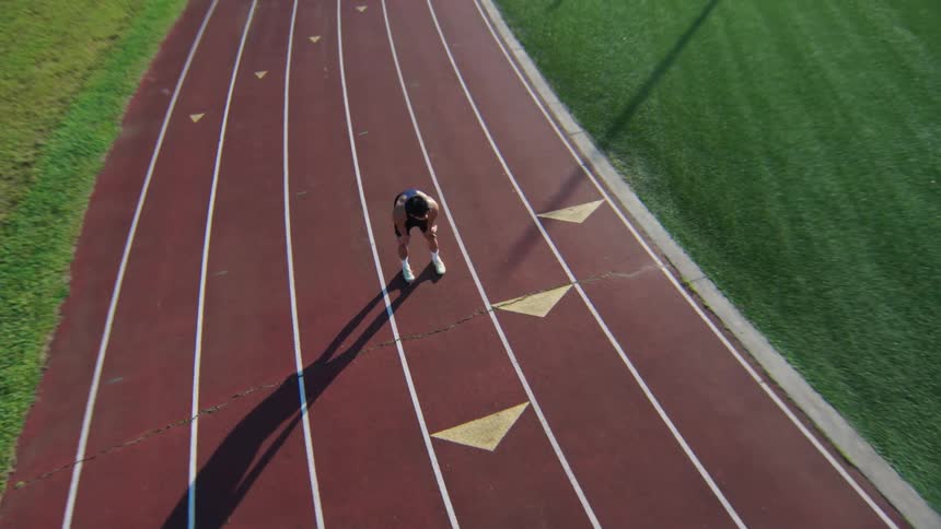 Man taking a deep breath while standing on a running track
