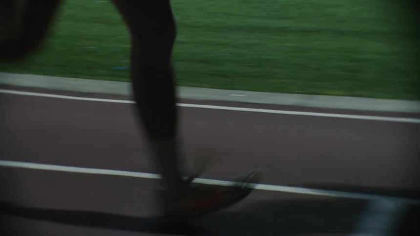 Legs of a man running on an athletics track