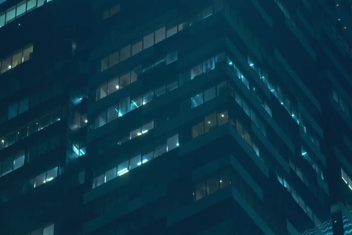 Skyscraper seen at night with lights on the buildings flashing