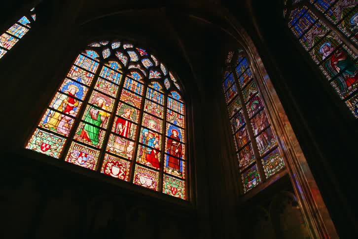 A large building with huge glass windows with designs painted on them