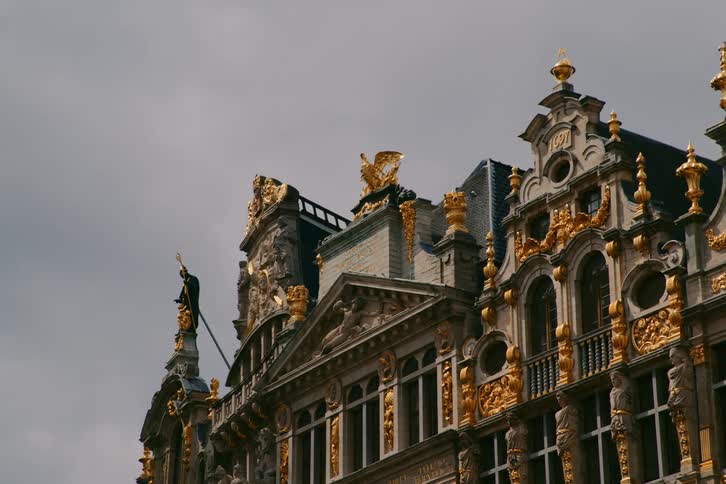 Facade of a classic building with gold decorations on a cloudy day