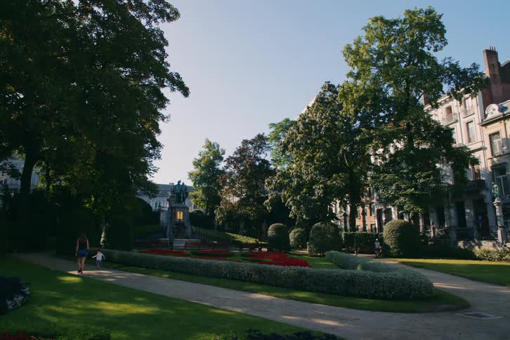 A mother and her son walk and run on a path on an estate
