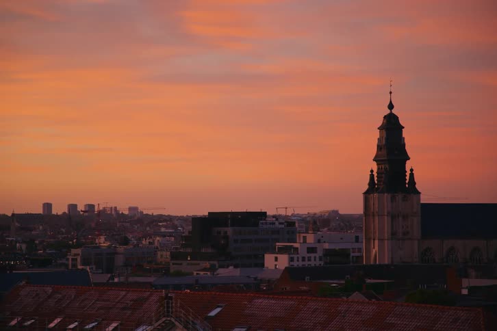 Landscape of a metropolis with a church in the background and an orange sky
