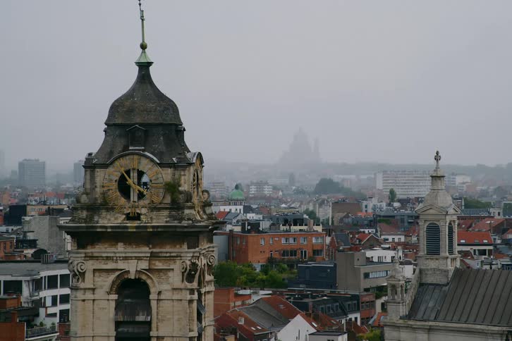A city with several houses and an old tower in the left corner and the background is foggy