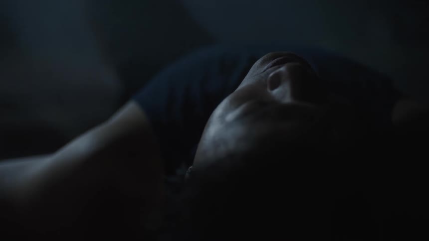 Tired man wearing a naval blue shirt lies on the ground
