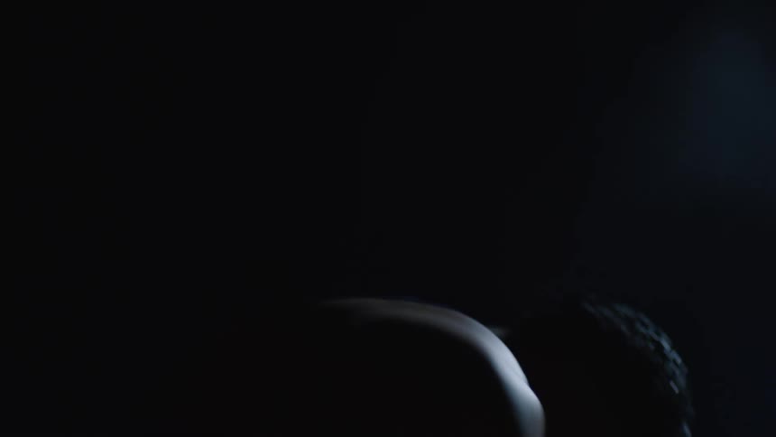 Man in an outdoor environment at night concentrated crouching down