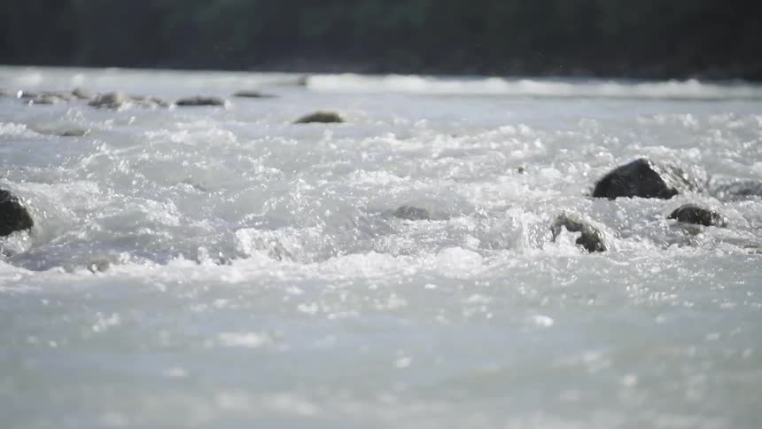 River water rolls over a small rocky rapids