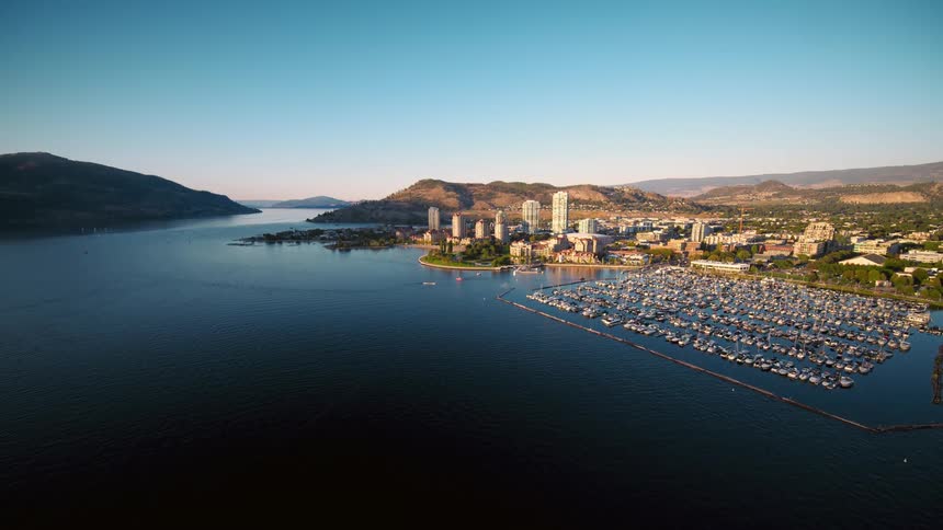 Aerial view of a city on the seafront with mountains on the horizon
