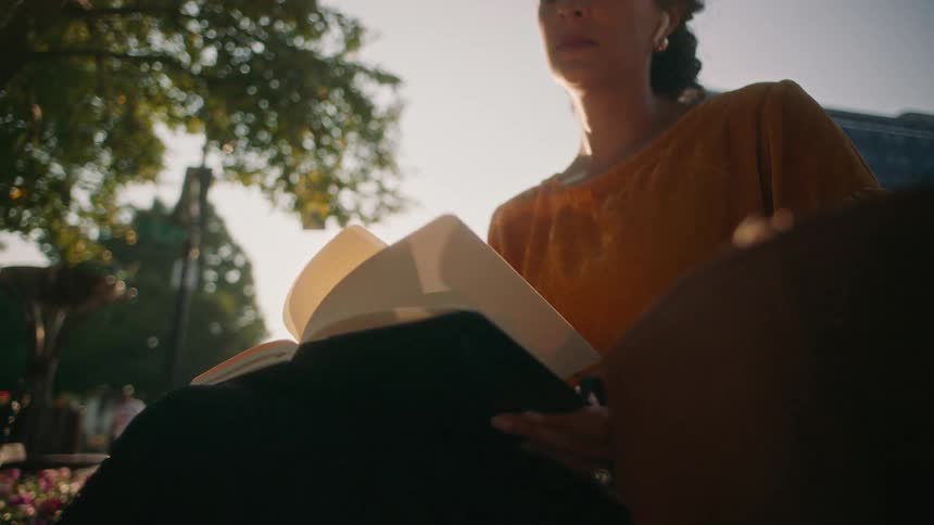 Woman sitting in a public place reading a book