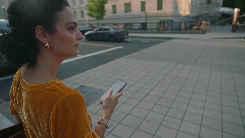 Woman holding a smartphone and watching the city