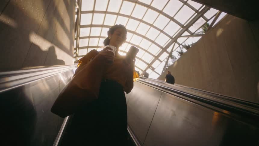 A clip of a lady on the stairs a beverage cup