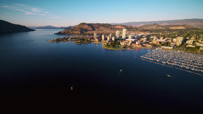 A metropolitan city with some large buildings it is on the coast of a large body of water