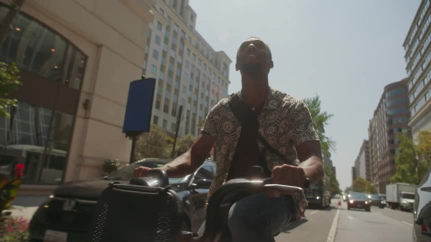 A man rides his bike down the city street