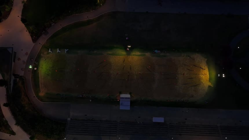 The field of a sports stadium lit up with lights at night