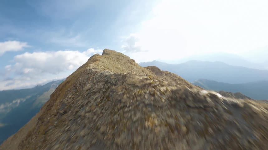Flying low over a large mountain range with multiple summits near deep valleys