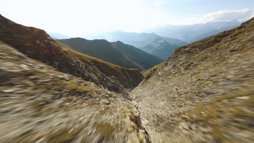 An aerial clip flying down a canyon on the side of a big mountain
