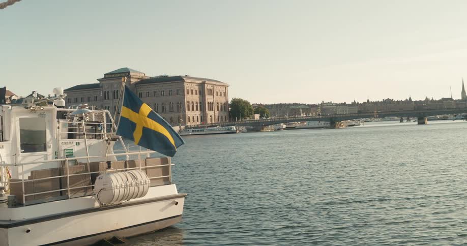 A swedish flag on a river boat flows in the wind