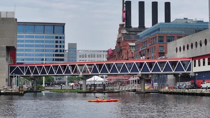 Two people paddling a kayak next to a metropolis