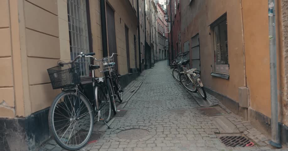Four bicycles parked in a narrow city street