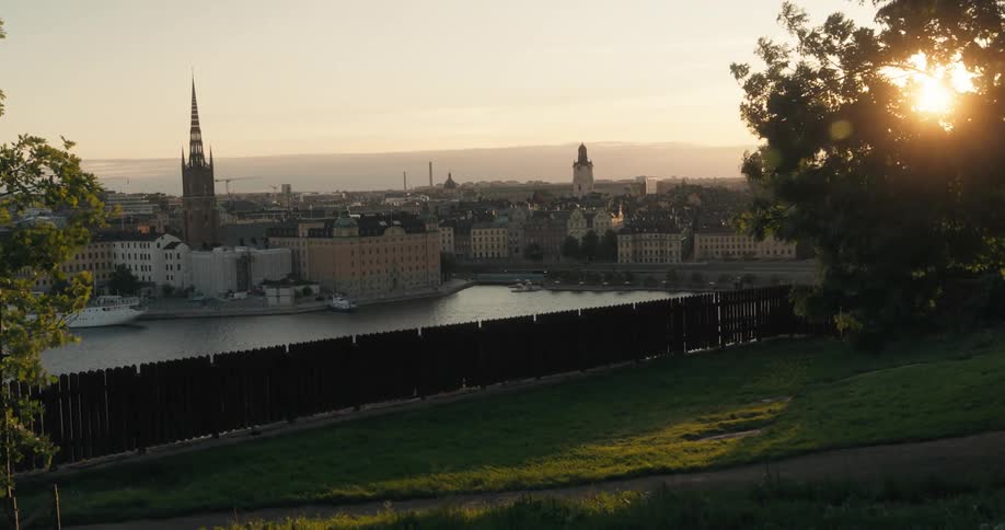 Landscape of an urban city by the sea with a golden sun on the horizon
