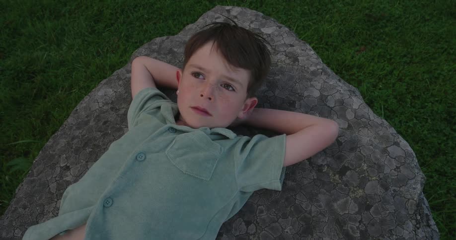 A child is laying on the rock