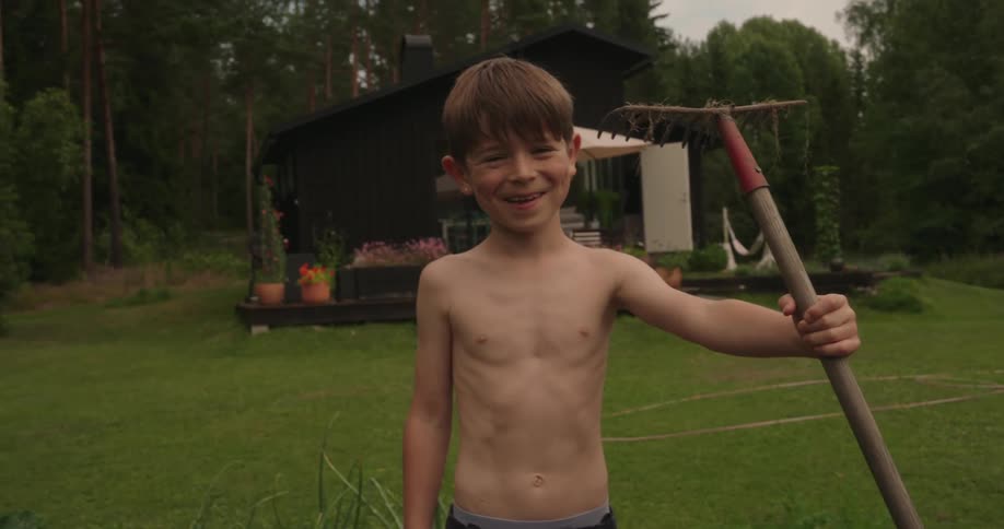 A boy holds a garden tool
