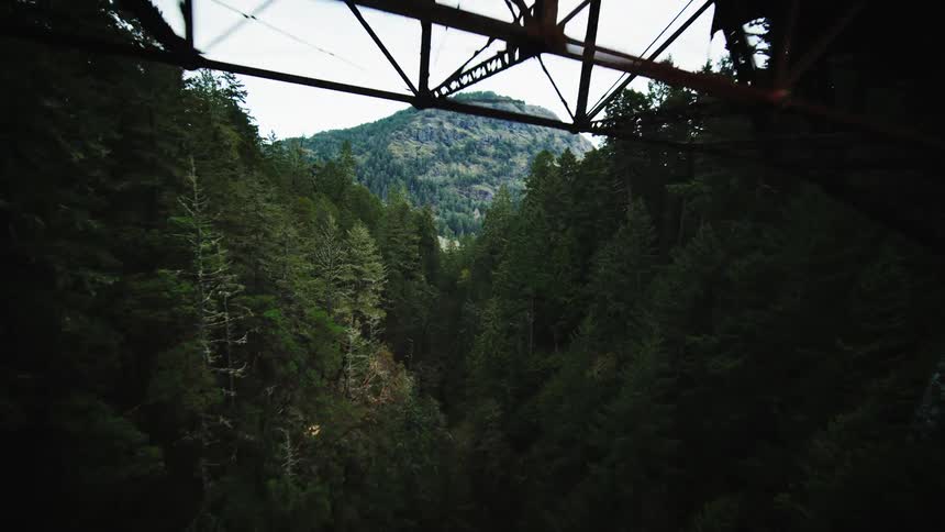 Aerial view of a long pedestrian suspension bridge spanning a deep gorge
