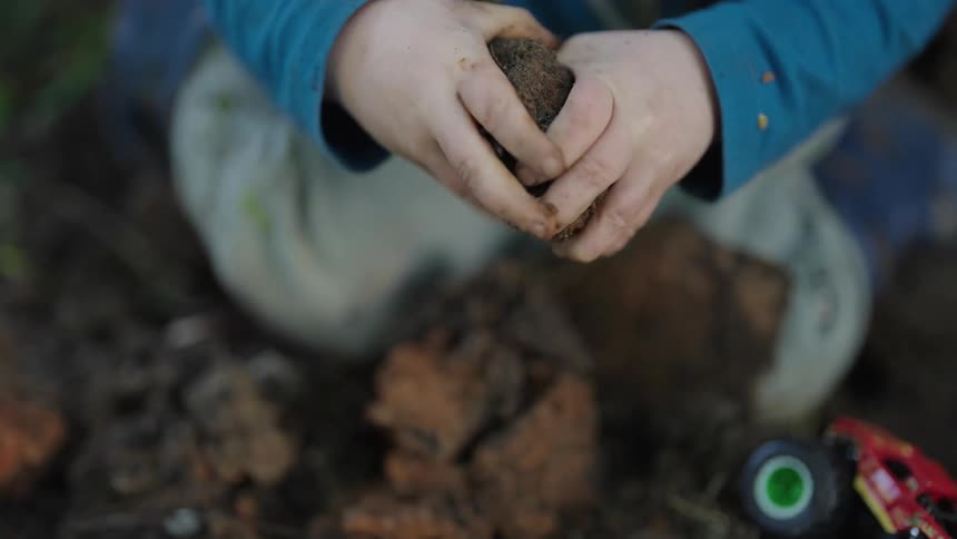 A clip of a kid playing with soil