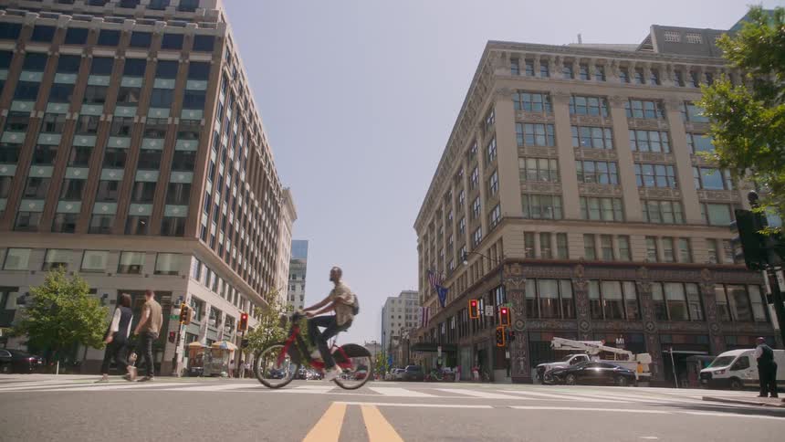 A city street scene with a cyclist crossing the road