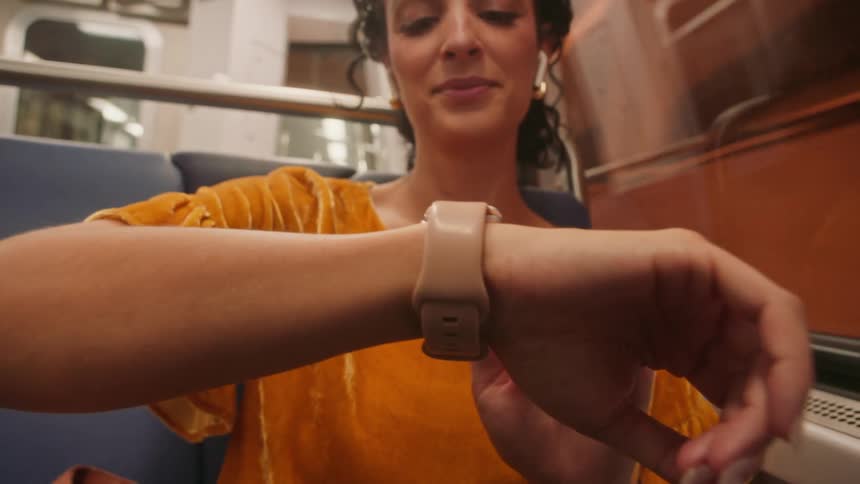 A woman is looking at her watch on the train