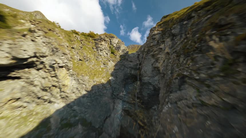 Flying Over a Rocky Mountain Trail, Following a Stream Through a Canyon