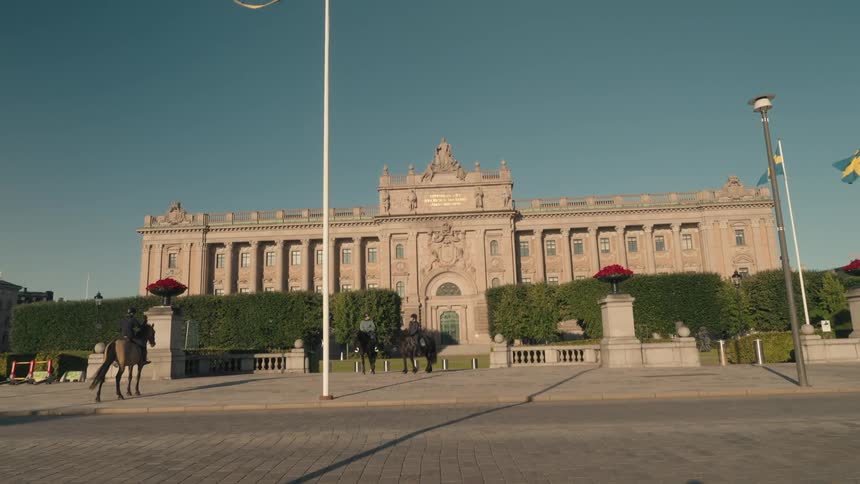 People on horseback are outside the stone building