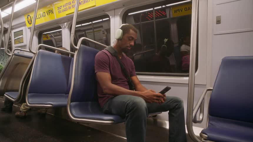 A man looks at his cellphone as he rides the train