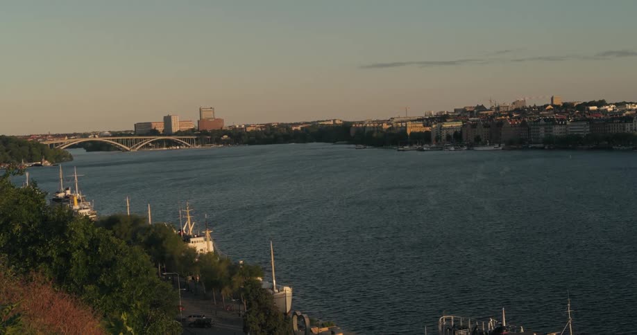 Maritime canal with a bridge and a city on the horizon in the late afternoon