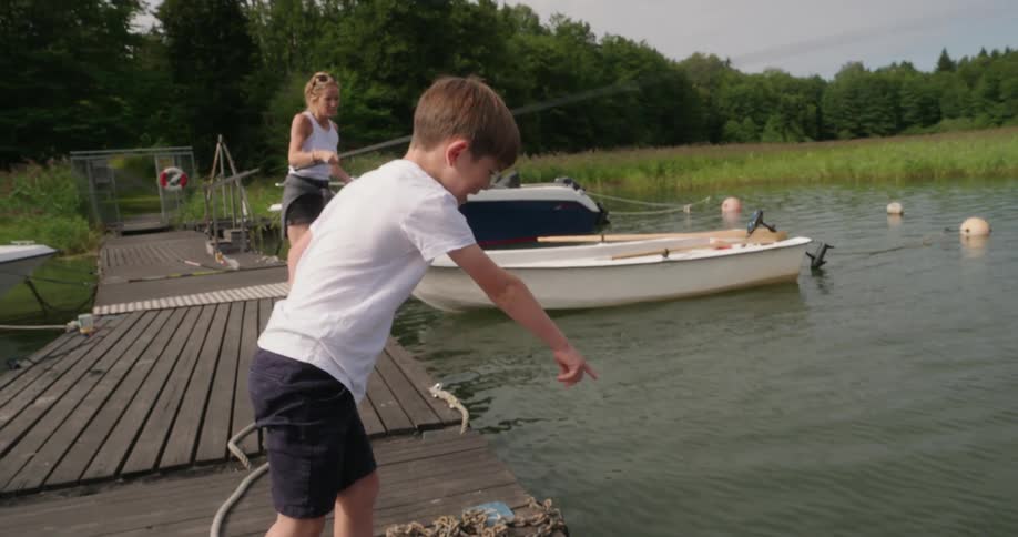 Mother and son on a pier fishing in a lake