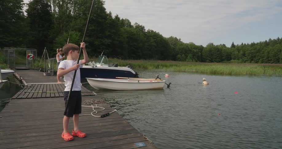 A child and woman are fishing on the pier