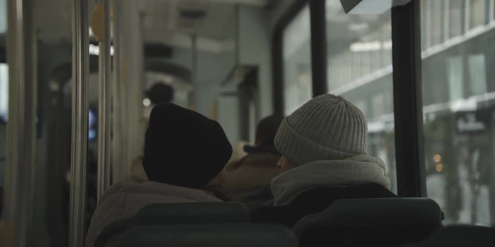 Back view of passengers heads seated on a bus looking towards the front