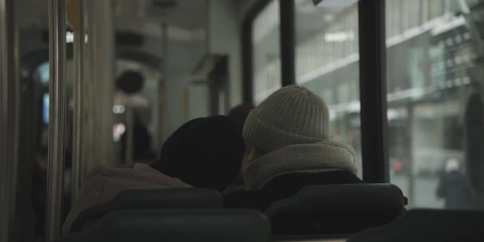 Couple and a group of people on a bus moving through the city