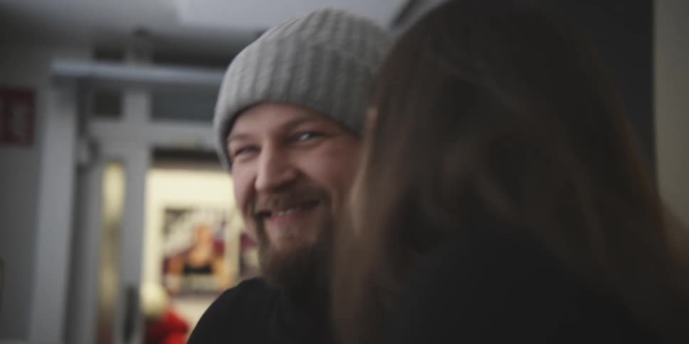 A young happy couple laugh and hug while enjoying a beverage on a restaurant