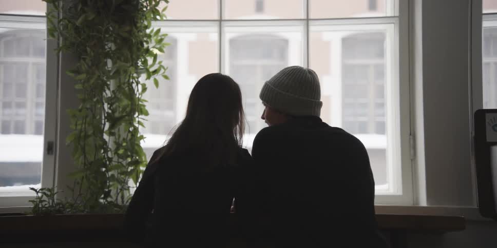 Back view of a man and a woman sitting and talking romantically