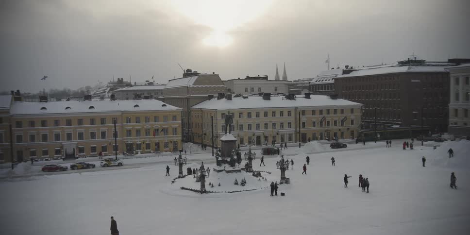 People in a public square in a city on a snowy day