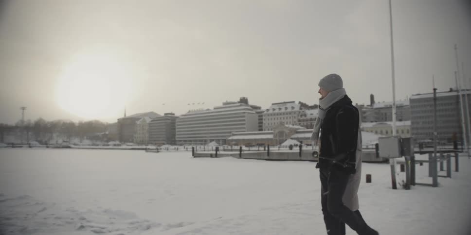 Couple holding hands walking on snow covered ground in city