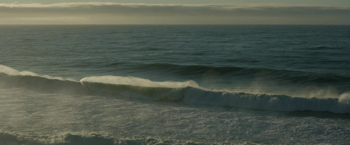 Aerial view of waves and an ocean seen one morning