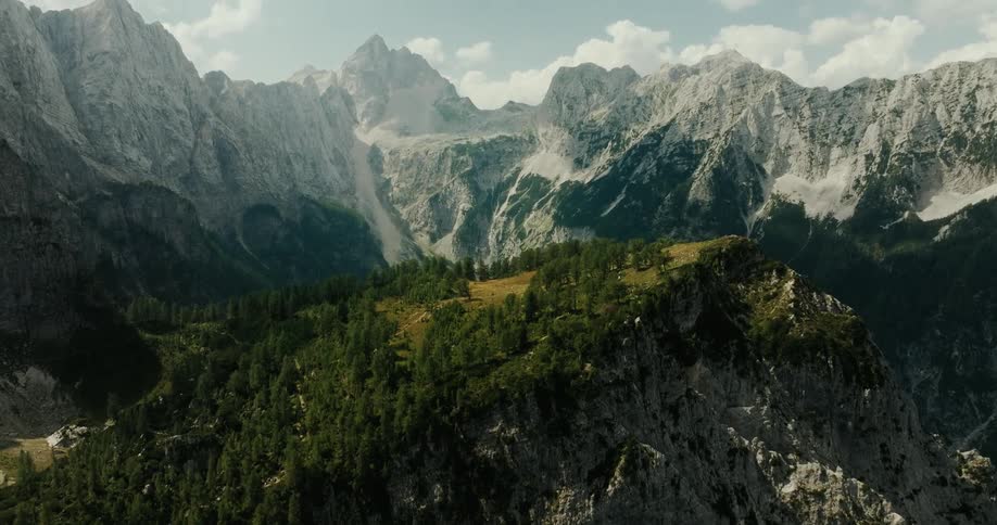 Panoramic view of a mountainous landscape with rugged peaks and forest on the slopes