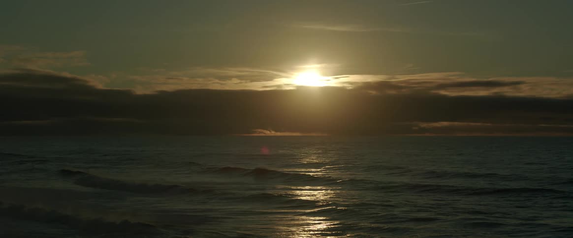 Sun sets over a large body of water