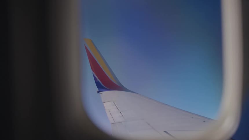 The airplane wing can be seen out the window